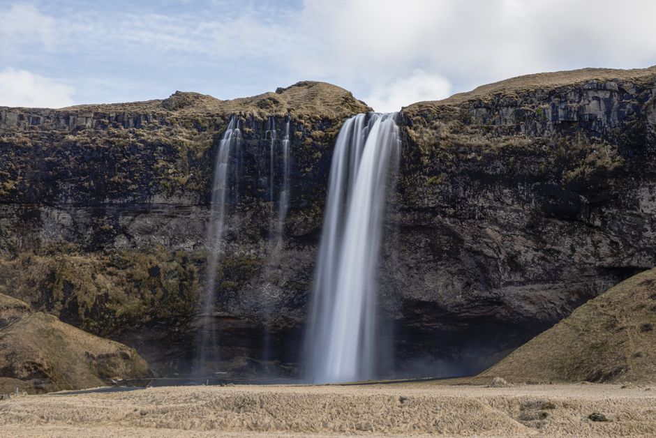 Breathtaking view of Seljalandsfoss waterfall cascading from cliffs in Iceland.